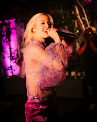 a blonde woman singing into a microphone