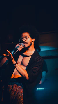 a man in a shirt singing into a microphone